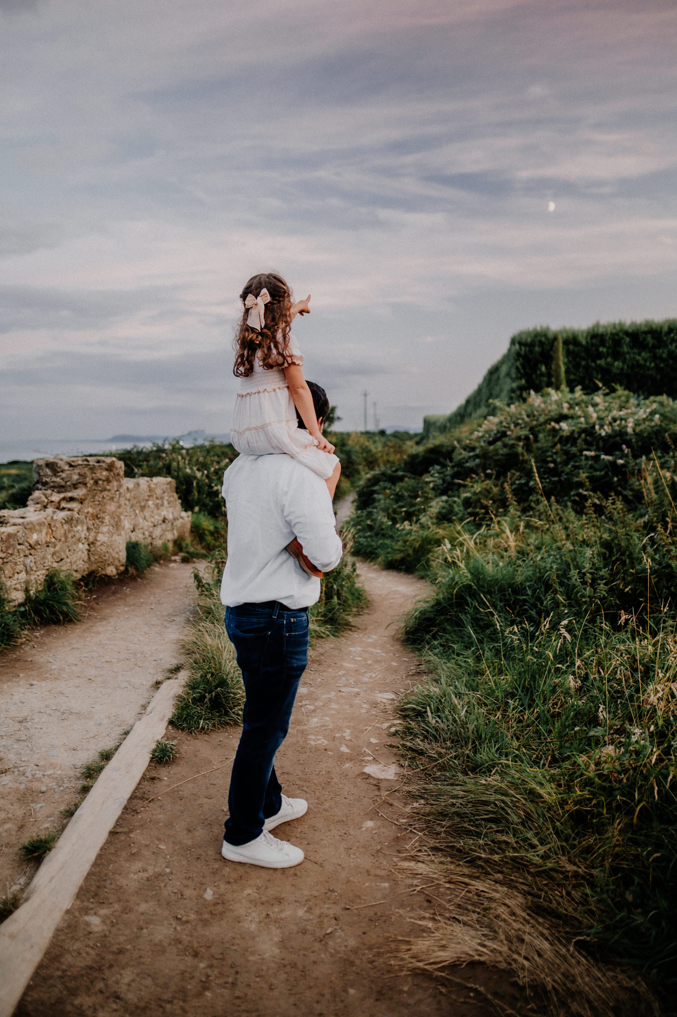Little-girl-on-daddys-shoulders-pointing-at-the-moon-in-Howth-kristina-kelly-photography